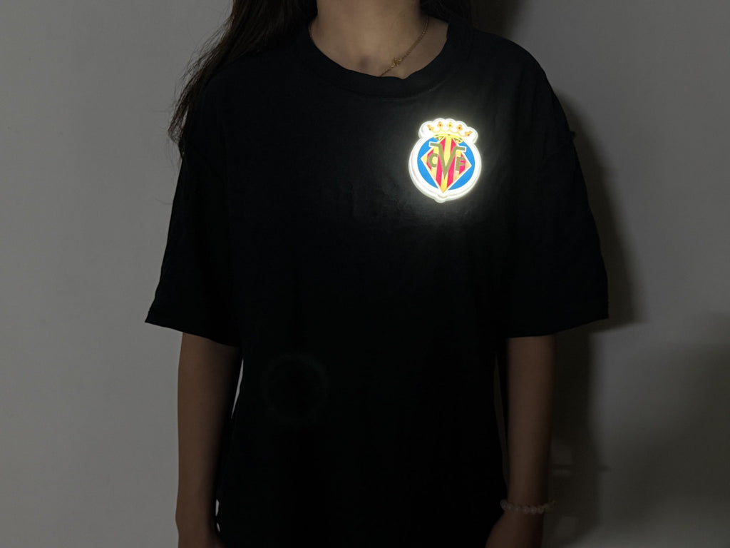 Escudo Luminoso Portable Villarreal CF encendido en una camiseta